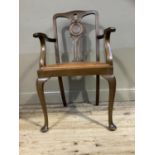 An early 20th century mahogany open elbow chair having a pierced splat with roundel, hide