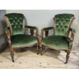 A pair of late Victorian button green upholstered armchairs on turned legs with casters