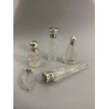 Five small cylindrical cut glass silver mounted perfume bottles, various dates