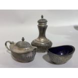 A three piece condiments set in silver, the salt and mustard with blue glass liners hallmarked