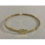 A bangle in 9ct gold, Elvis pierced within a guitar outline in presentation box, approximate