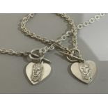 A necklace of silver trace links hang with a heart shaped 'Elvis' charm engraved 'Love me tender' to