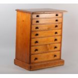 A VICTORIAN MAHOGANY SPECIMEN CHEST of seven graduated drawers with turned button handles, on plinth