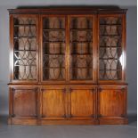 A GEORGE IV MAHOGANY BREAKFRONT BOOKCASE-CUPBOARD, having a moulded and fluted cornice above four