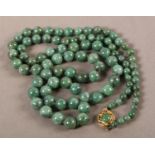 A JADE NECKLACE c.1930, the graduated circular nephrite beads fasted with a pierced and scroll