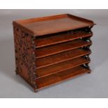 A VICTORIAN WALNUT SHEET MUSIC RACK OF FIVE COMPARTMENTS, the side panels fret cut in a design of