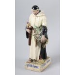 S K COPE AN ART POTTERY MODEL OF A MONK, c.1920s carrying a basket brimming with fishes and