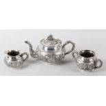 A CHINESE SILVER THREE PIECE TEA SERVICE, c.1900, embossed with chrysanthemum and foliage on
