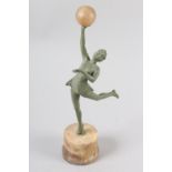 AN ART DECO VERDIGRIS - FINISHED METAL FIGURE OF A DANCER, her arm raised and holding an alabaster