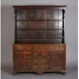 A 19TH CENTURY OAK DRESSER AND RACK, having a moulded cornice above a planked back with three