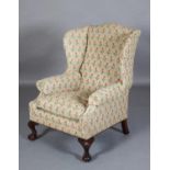 A GEORGE III STYLE WINGED ARMCHAIR ARCHED BACK AND SERPENTINE FRAME, tapestry close nailed
