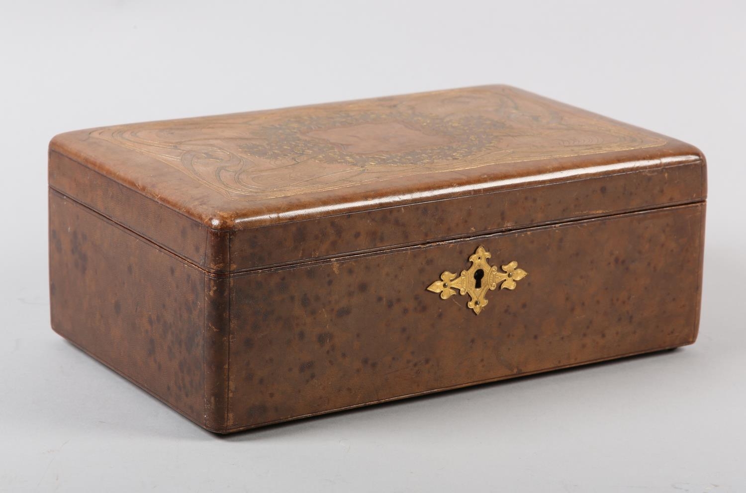 AN ART NOUVEAU BROWN LEATHER BOX, rectangular, the lid gilt tooled with plant forms and ribbon