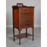 AN EDWARD VII MAHOGANY AND SATINWOOD BANDED MUSIC CABINET having a raised and pierced three-