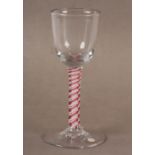 A SMALL WINE GLASS, the bucket bowl set on a stem with triple-series red and white opaque twists and