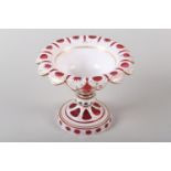 A 19TH CENTURY BOHEMIAN RUBY AND WHITE OVERLAY COMPORT with gilt highlighting having a leaf cut rim,