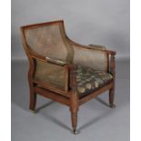 A REGENCY MAHOGANY BERGÈRE LIBRARY CHAIR, with serpentine shaped back, upholstered arm pads and