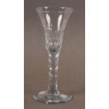 A WINE GLASS, the trumpet bowl panel cut to lower half on a faceted stem and conical foot facet