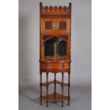 AN AESTHETIC MOVEMENT WALNUT STANDING CORNER CABINET, having a stylised petal pediment each carved