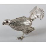 A DUTCH SILVER SALT OR PEPPER SHAKER MODELLED AS A GAME BIRD, with ruby coloured eyes, hinged wings,