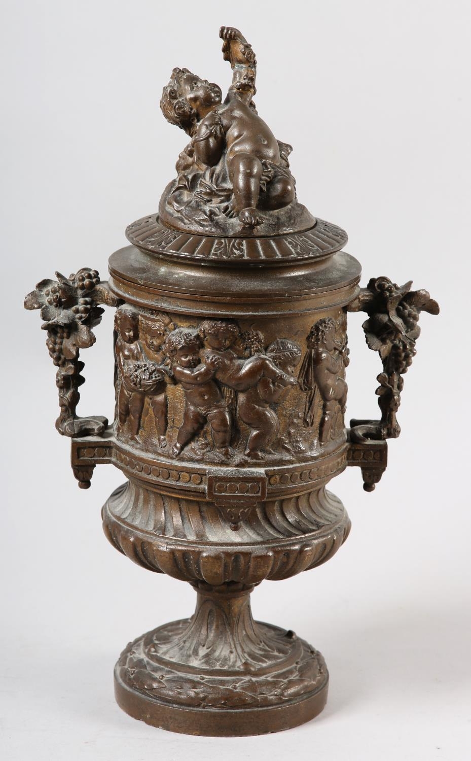 A 19TH CENTURY BRONZED METAL BACCHANALIAN TWO HANDLED CUP AND COVER, having a figural finial, the