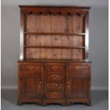AN EARLY 19TH CENTURY OAK BREAKFRONT DRESSER AND RACK, having a moulded cornice and a scalloped