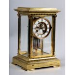 A LATE 19TH CENTURY FRENCH FOUR LIGHT STRIKE CLOCK in a brass columned case, the four bevelled
