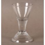 A WINE GLASS with drawn trumpet bowl rising from a short plain stem over a tall conical folded