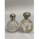 TWO GLOBULAR CUT GLASS SCENT BOTTLES, one plain with writhen flutes and silver screw top with flutes