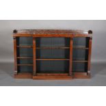 A REGENCY ROSEWOOD BREAKFRONT BOOKCASE having a three quarter foliate pierced gallery above