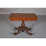 A VICTORIAN FIGURED A WALNUT CARD TABLE, having a rectangular fold-over top lined in baise, on a