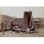 FRANK MEADOW SUTCLIFFE (1853-1941), Farm girls feeding the chickens beside a tall haystack, c.