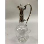 A Victorian plain glass silver mounted claret jug with double scroll handle etched with a leopard