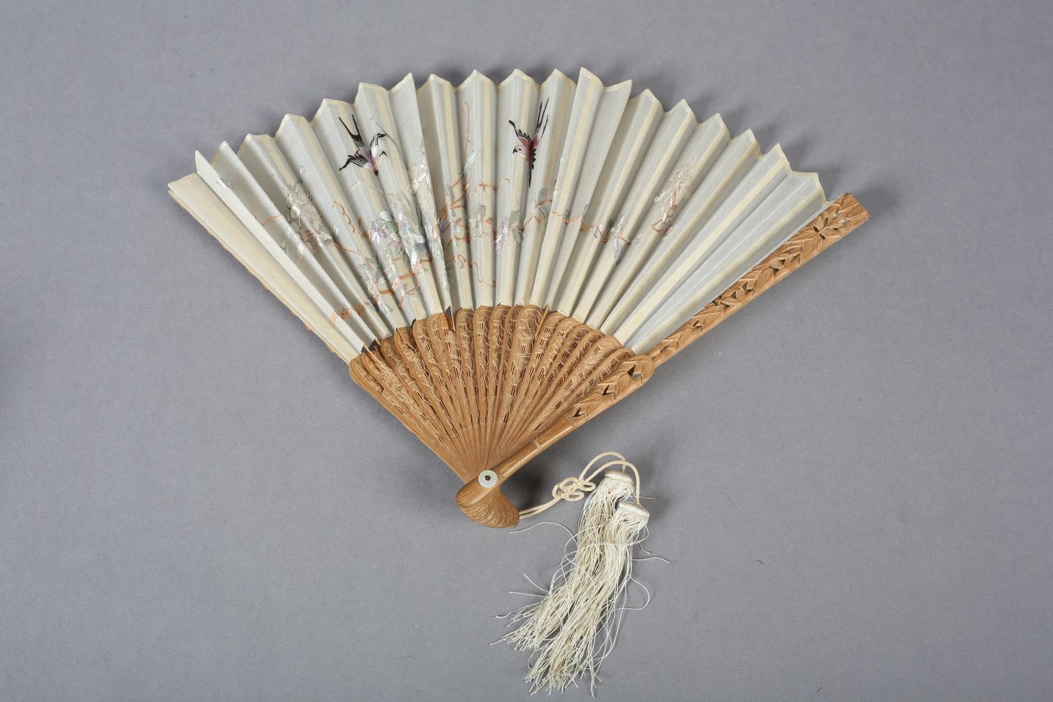 A 20th century Chinese carved sandalwood fan, the white cotton gauze embroidered with two