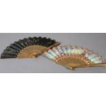 A third quarter 19th century wood fan with painted silk leaf, the monture painted in gold, carved,
