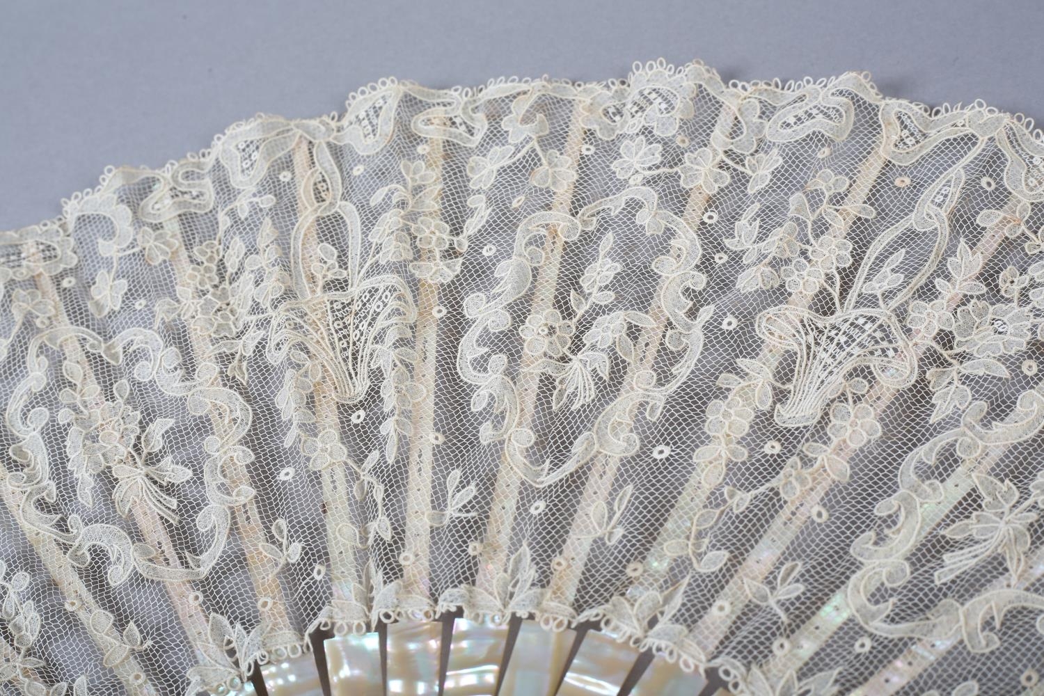 A folding fan c 1900 with pink mother of pearl monture, continuing onto the ribs, the lace leaf of a - Image 3 of 5