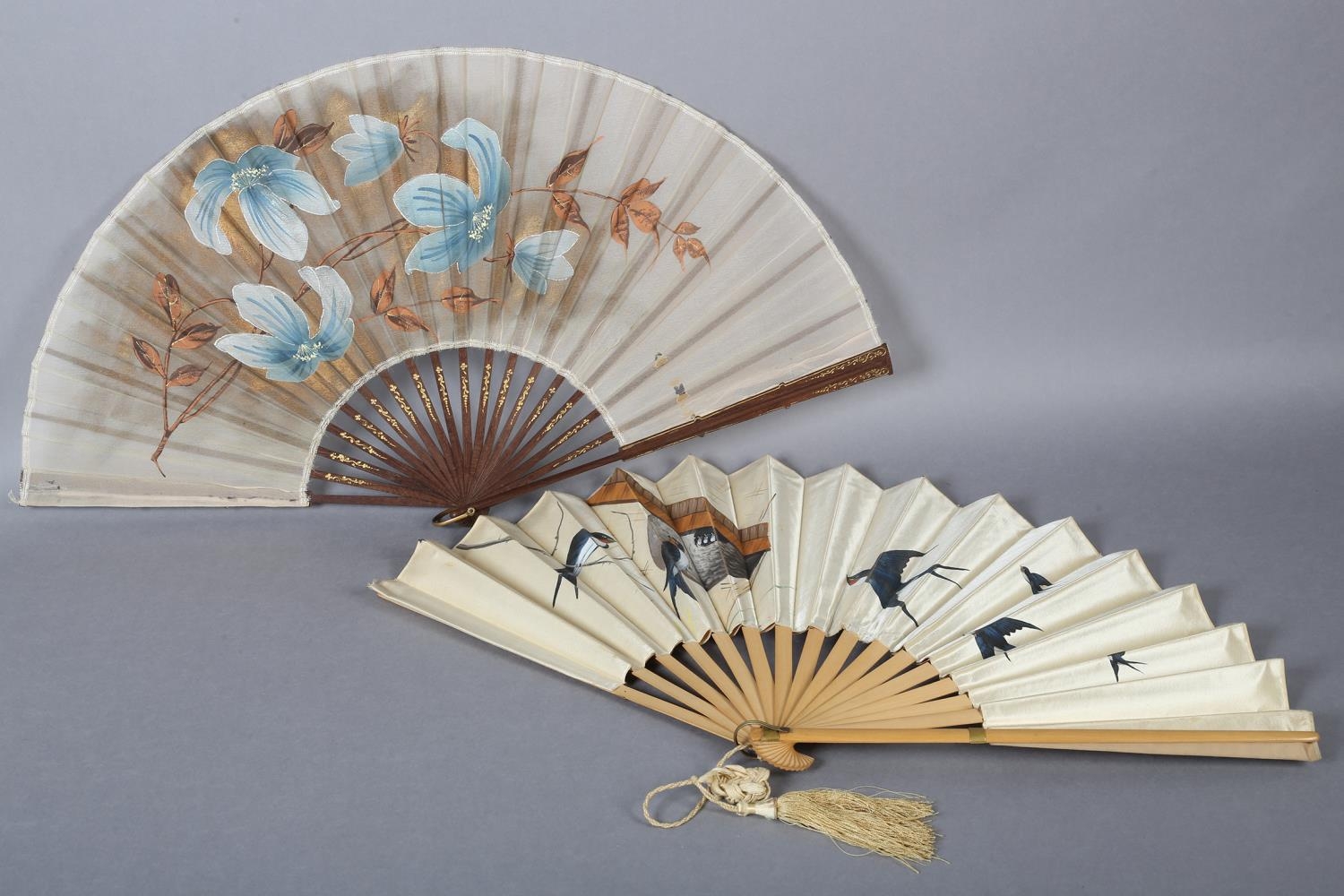 A good late 1890’s wood fan, the cream silk satin leaf panted with birds returning to a nest in