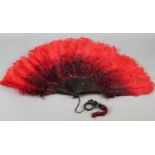 c.1900, an ostrich feather fan, the plumes deep plum shaded to red, with tortoiseshell monture,