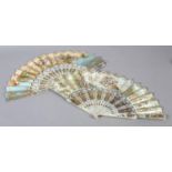 Two white mother of pearl mid-19th century fans, elaborately gilded and silvered, the leaves
