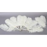 A late 19th century white ostrich feather fan, the monture of white mother of pearl, plain other