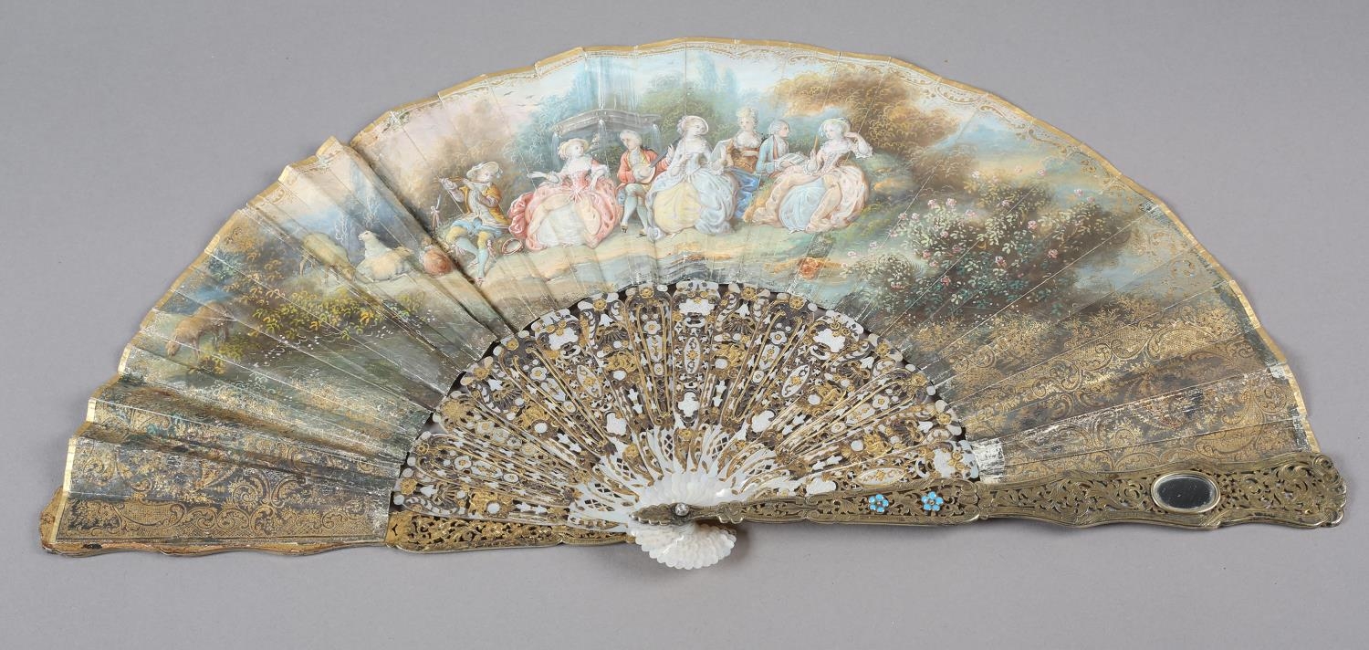 An ornate mid-19th century mother of pearl fan, the guards entirely of carved and pierced gilt