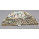 An ornate mid-19th century mother of pearl fan, the guards entirely of carved and pierced gilt
