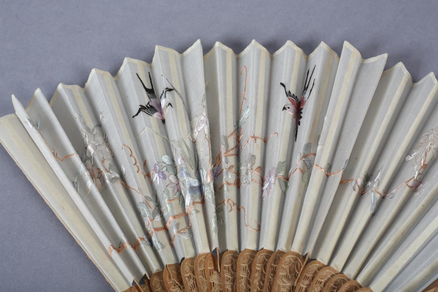 A 20th century Chinese carved sandalwood fan, the white cotton gauze embroidered with two - Image 2 of 5