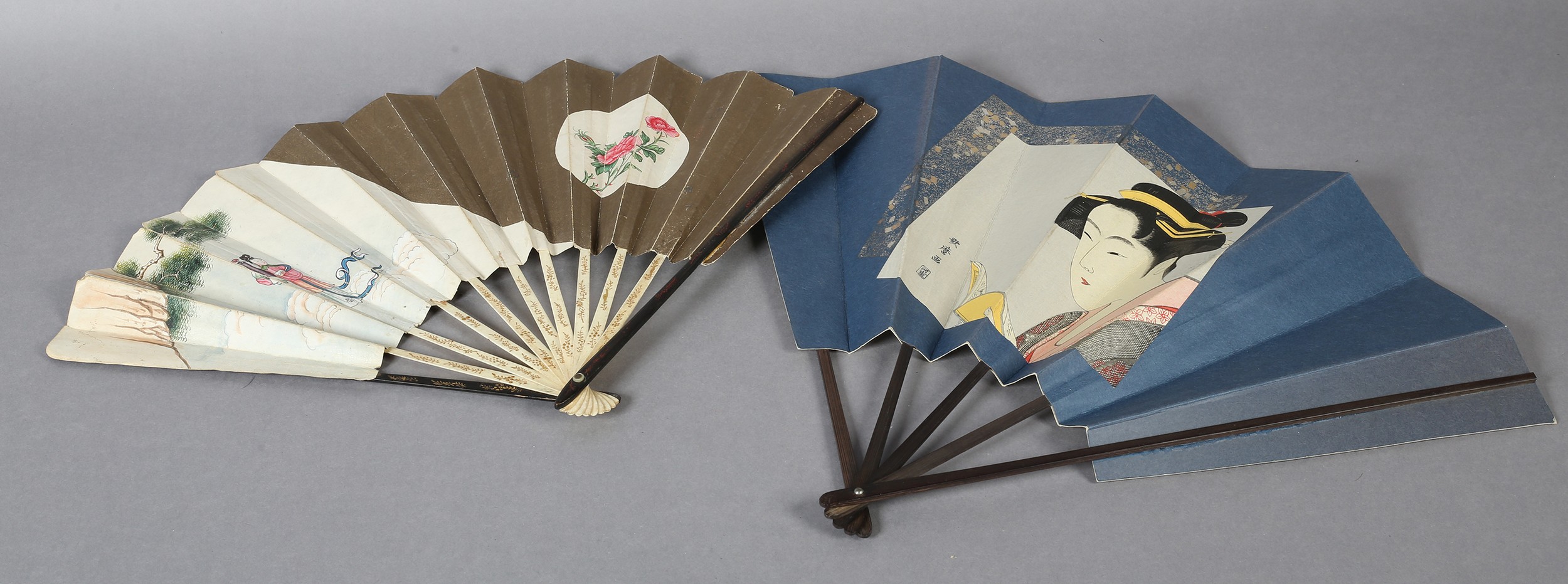 Two large Japanese fans, the first with a central portrait of a geisha, with hair accessories and