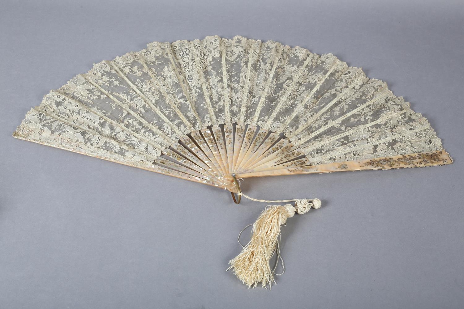 A good large Brussels Point de Gaze lace fan, c 1890, the monture of shiny pink mother of pearl,