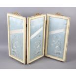 A dressing table or boudoir screen, three padded, concertina-folding panels of cream painted wood