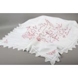 An autographed friendship tablecloth, linen embroidered in red with multiple names of the