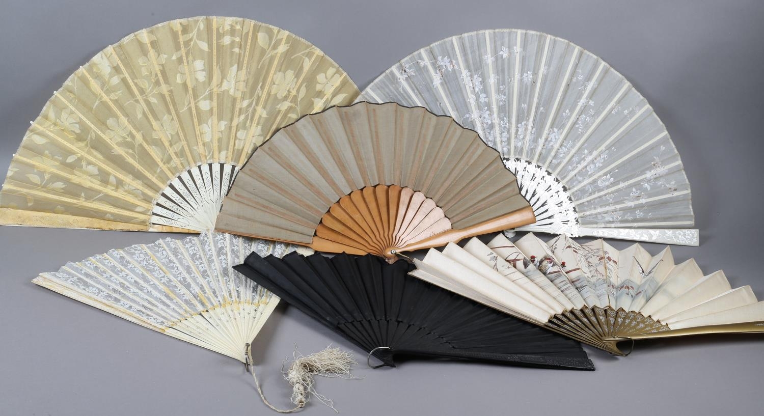 Seven late 19th century fans of large size, the first with wood monture painted gold, and