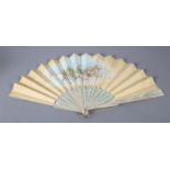 A painted silk fan signed “Jolivet”, the cream leaf painted with a solitary maiden in a garden