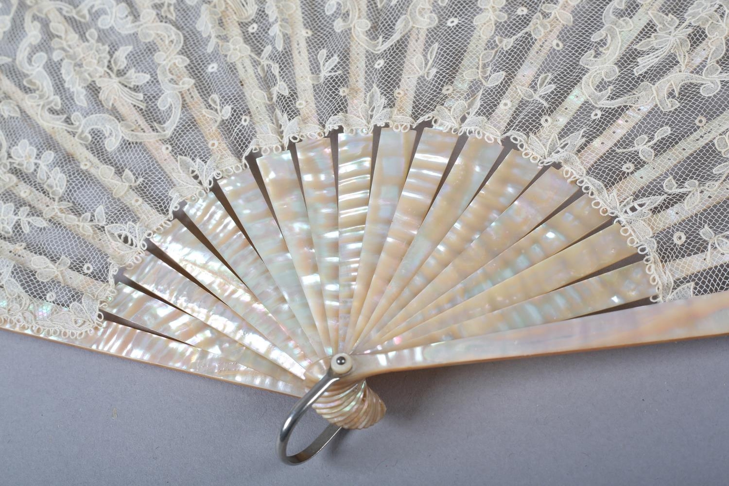 A folding fan c 1900 with pink mother of pearl monture, continuing onto the ribs, the lace leaf of a - Image 2 of 5