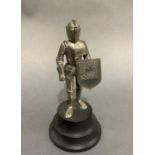 A mid 20th century musical table lighter in the form of a knight in armour his shield printed with